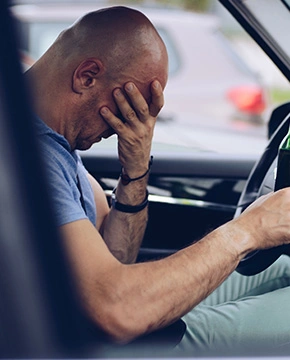 Drunk driver drinking alcohol in car and holding beer bottle