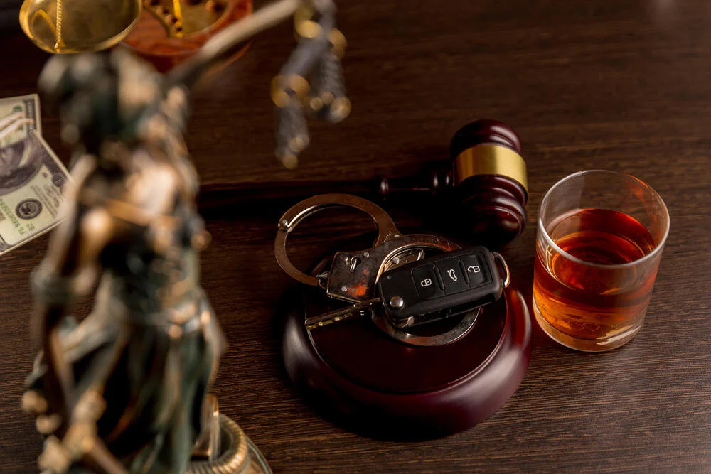 Whiskey with car keys and handcuffs. Concept for drinking and driving