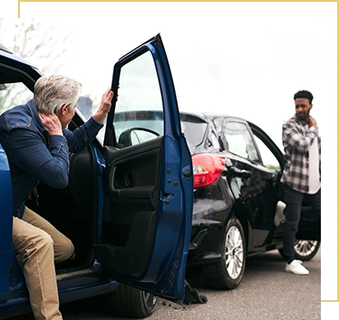 Senior and younger male drivers get out of cars and inspect damage after road traffic accident