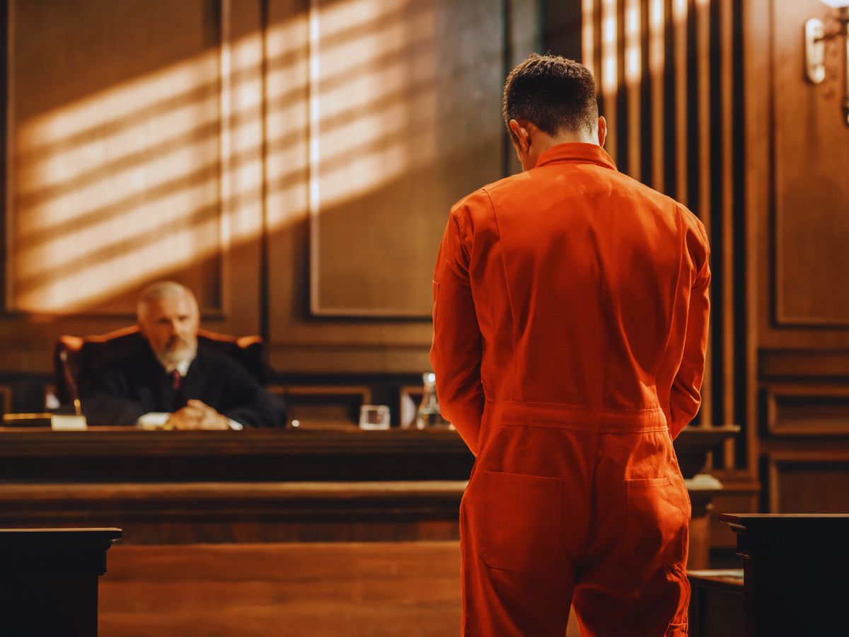 A worried individual standing in a courtroom, facing criminal charges in California.