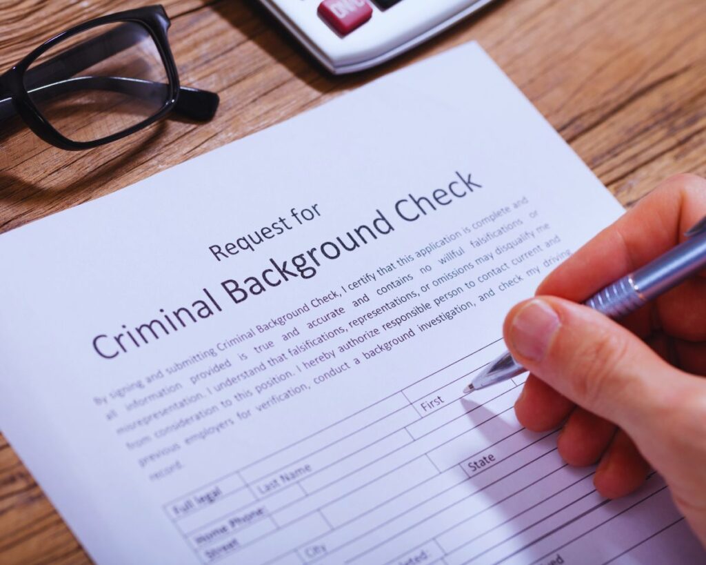 Person filling out a form for a criminal record background check, focusing on the expungement process.