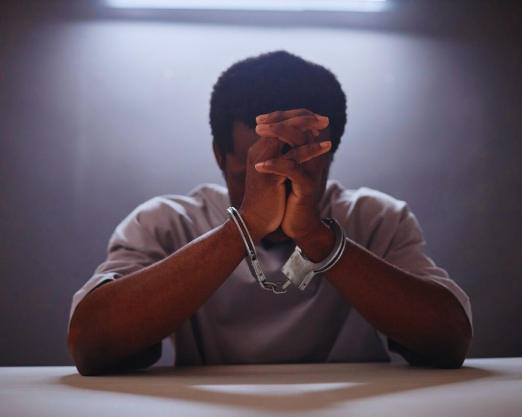 Criminal Defense Lawyer Shaffer Cormell: A sad man in handcuffs facing criminal charges.