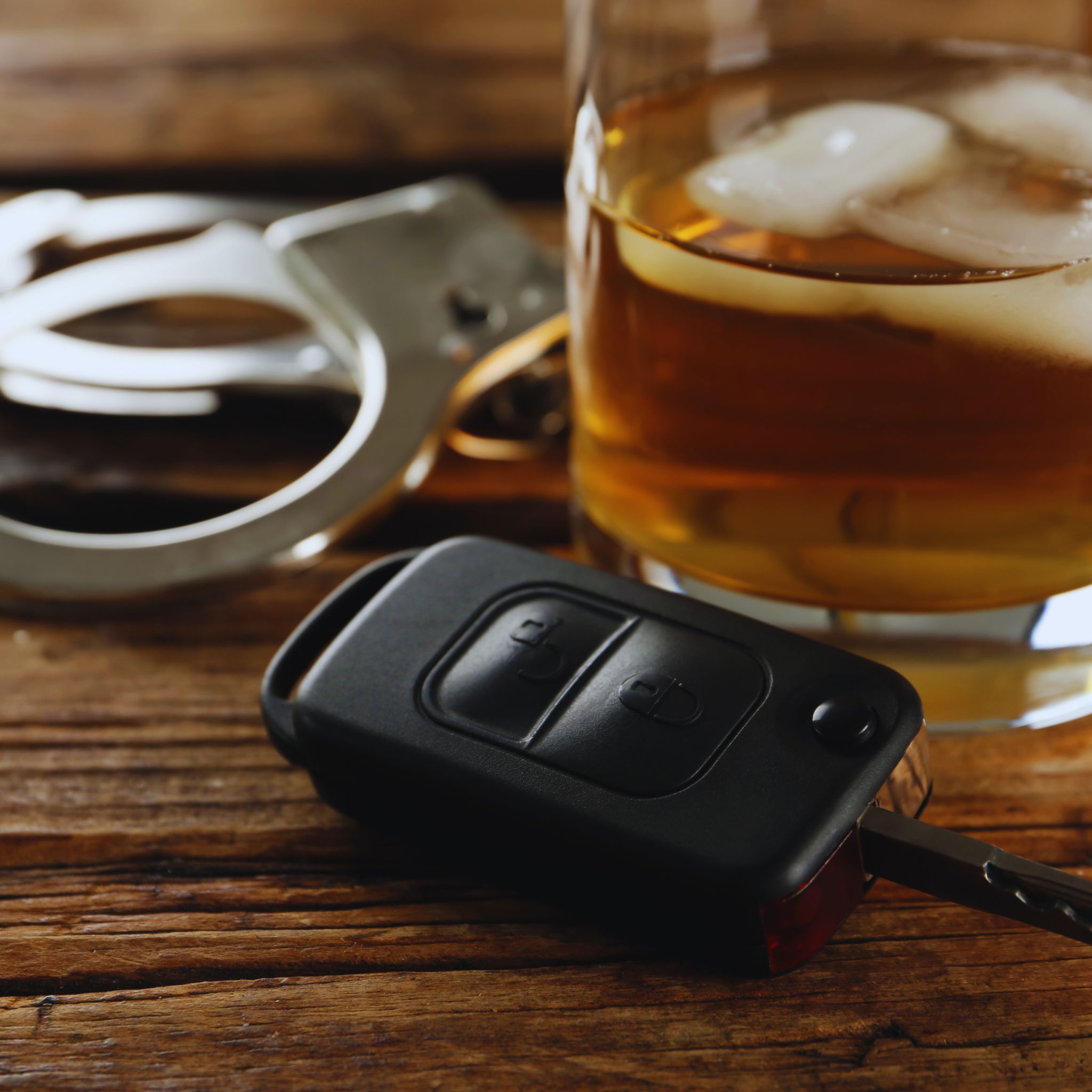 DUI Expungement: Handcuffs, a bottle of alcohol, and a car key representing DUI expungement.