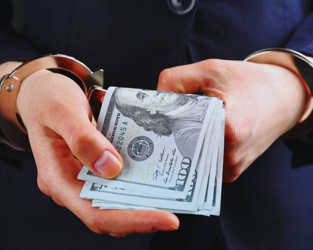 A driver in handcuffs paying bail after being caught driving under the influence, highlighting California DUI bail procedures.