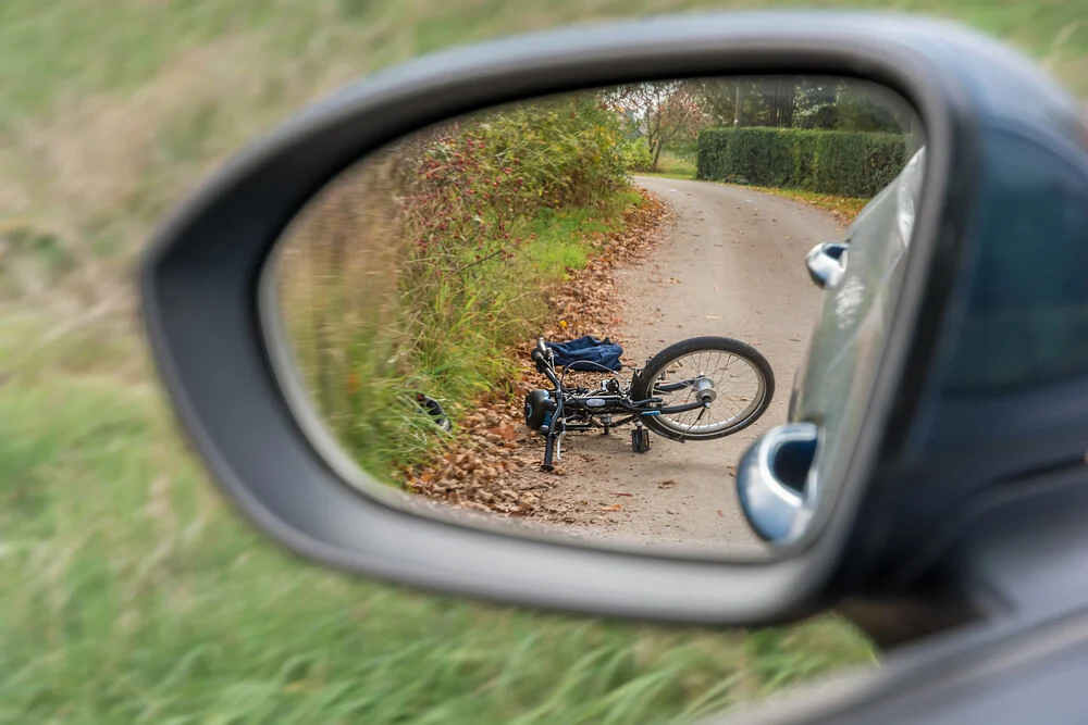 Accident between a car and a cyclist presented with bicycle in the rearview mirror